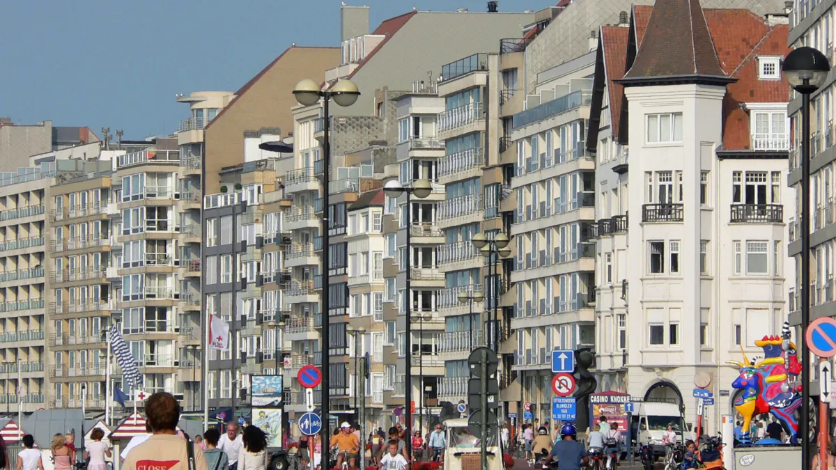Promenade du Zoute à Knokke : immeubles à appartements, lampadaires et promeneurs par beau temps