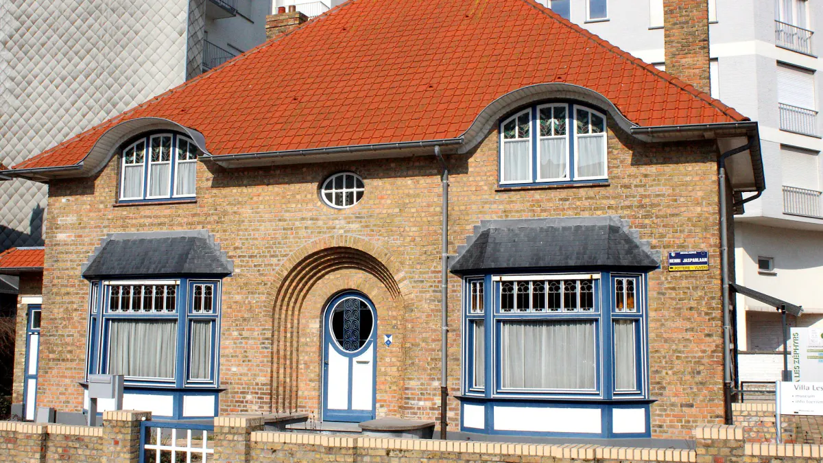 Villa en briques à toit de tuiles rouges et fenêtres encadrées de bleu à Westende