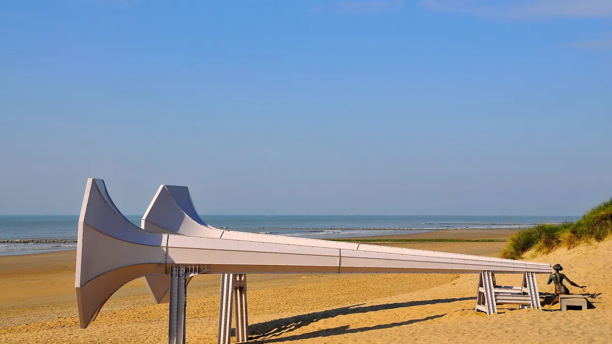Sculpture blanche en forme de grand cornet posée sur la plage de Westende, mer à l'horizon